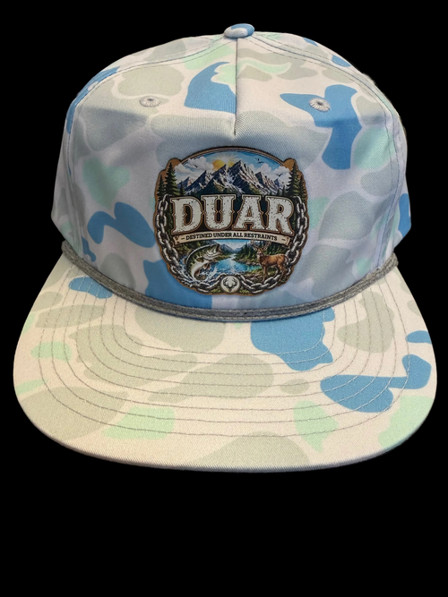 Camouflage-patterned cap with a logo and text on a wooden surface